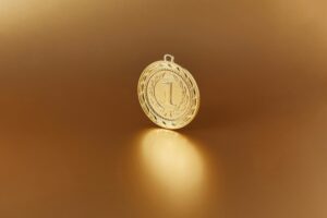 Close-up image of a golden number one medal on a soft golden background.